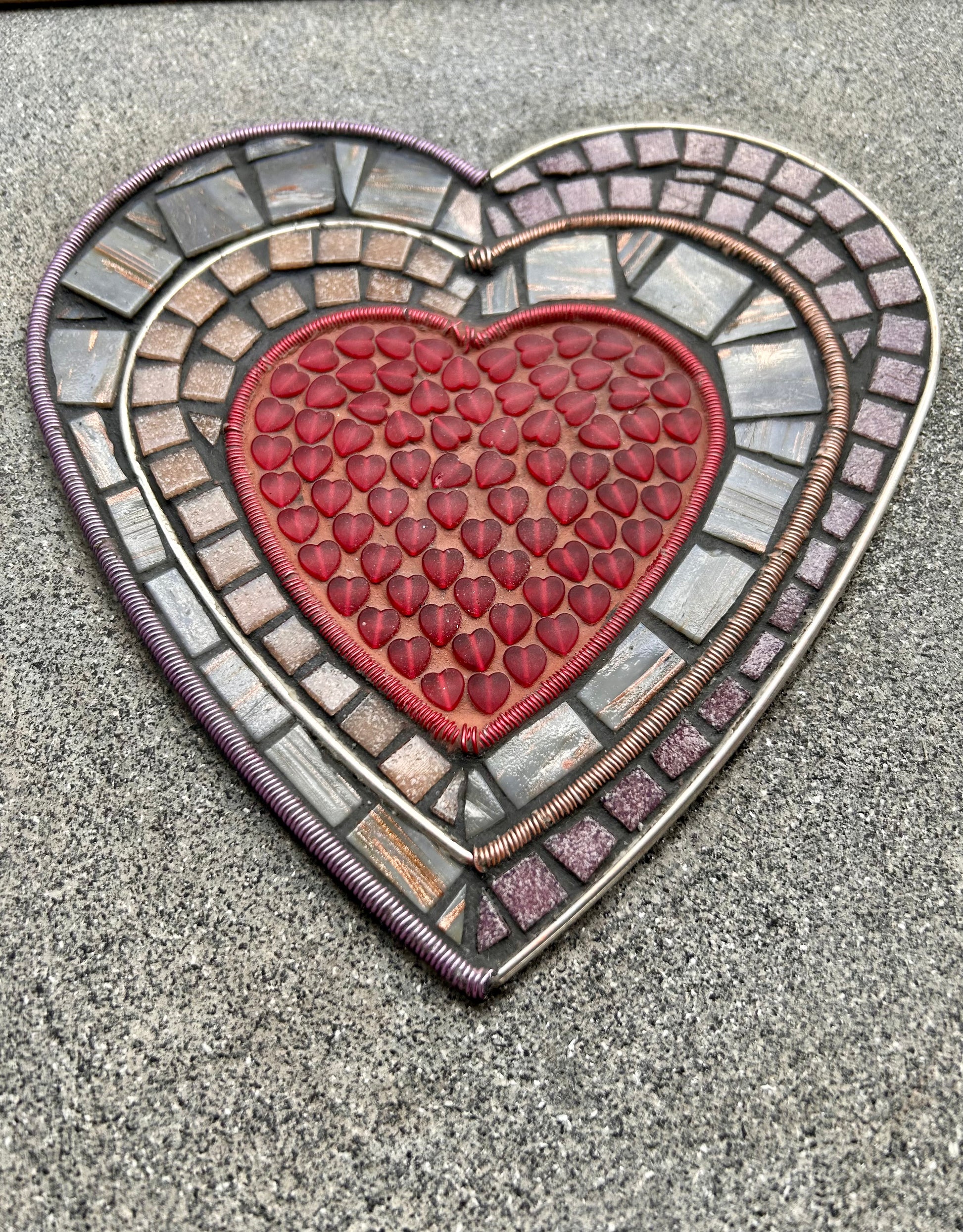 Handmade Mosaic Art,  "Walls" mosaic artwork, viewed from the front, featuring a red heart surrounded by layers of wire wrapped by hand and hand-cut mosaic tiles, framed in a wood frame.