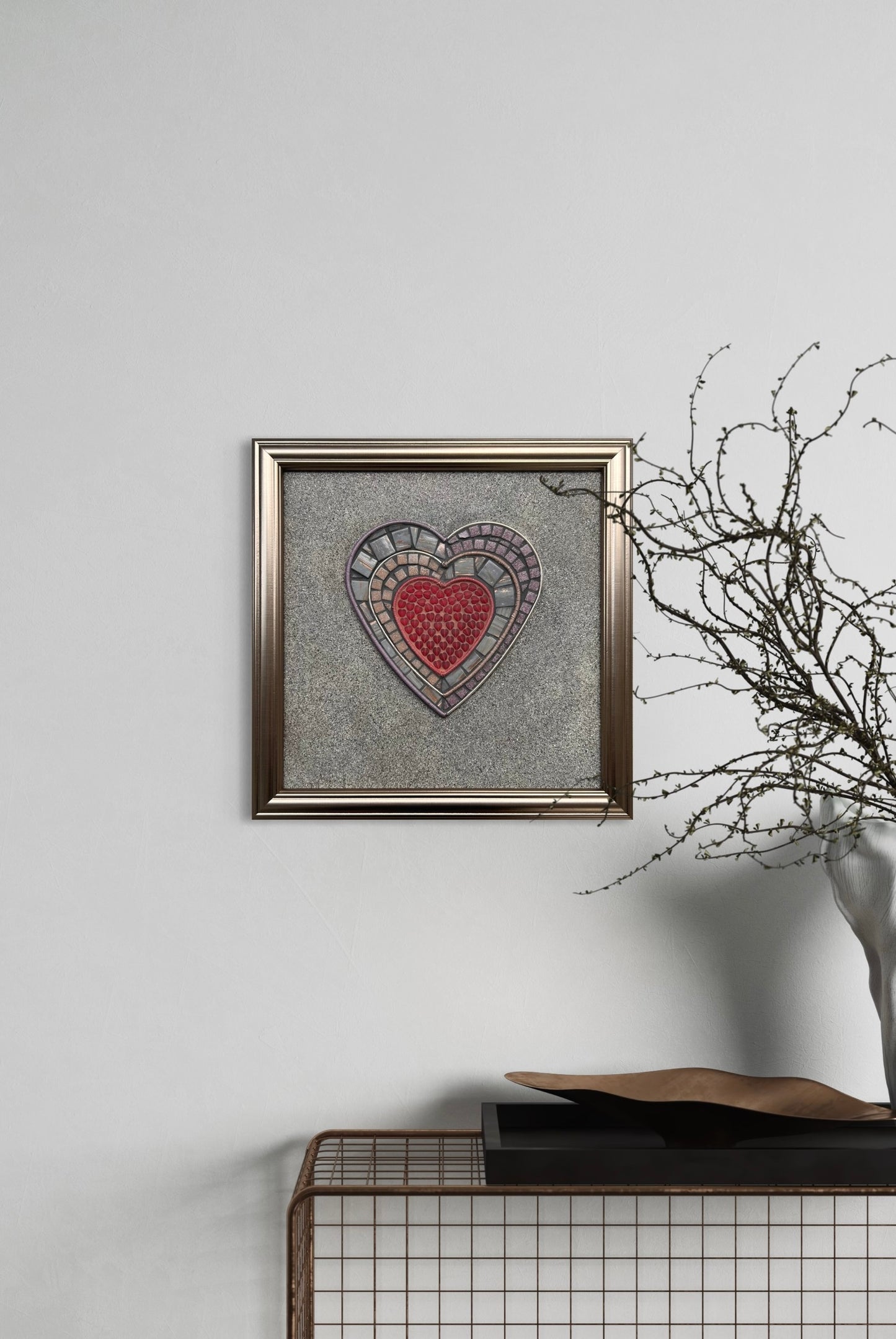 Handmade Mosaic Art,  "Walls" mosaic artwork, viewed from the front, featuring a red heart surrounded by layers of wire wrapped by hand and hand-cut mosaic tiles, framed in a wood frame on the white wall